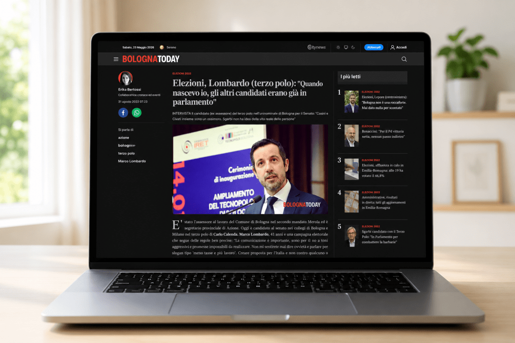 Mockup di un articolo online relativo alla campagna elettorale 2022 visualizzato su laptop in un ambiente domestico minimale e luminoso.