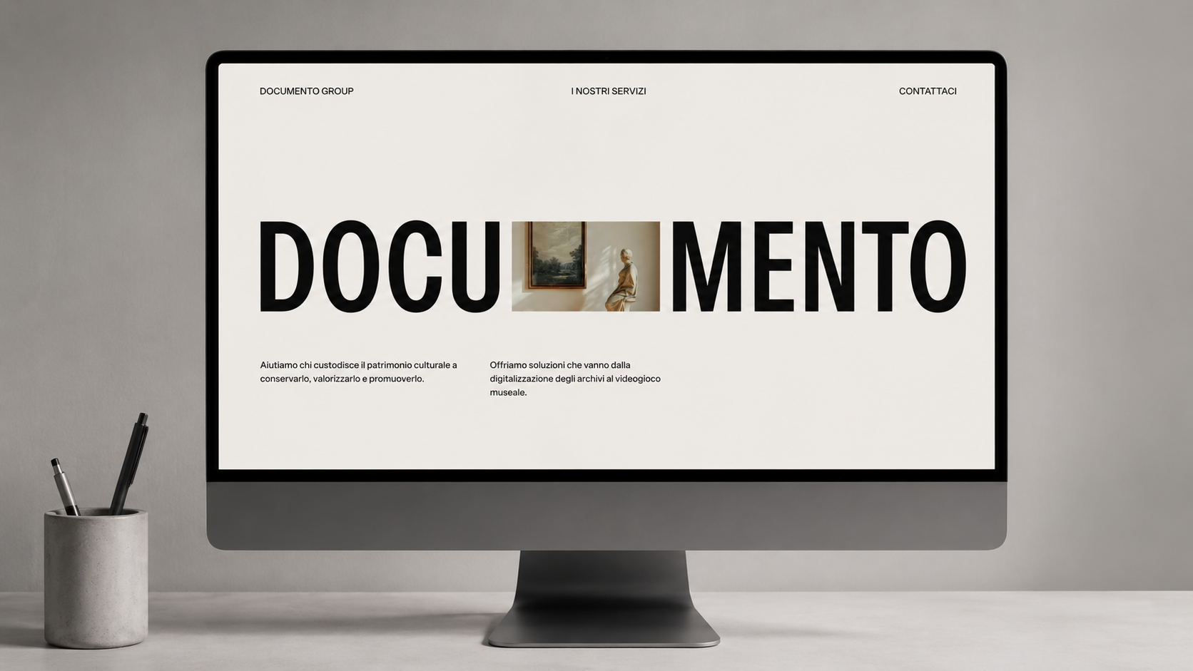 Mockup desktop della landing page di Documento Group visualizzata su monitor in un ambiente minimal contemporaneo.
